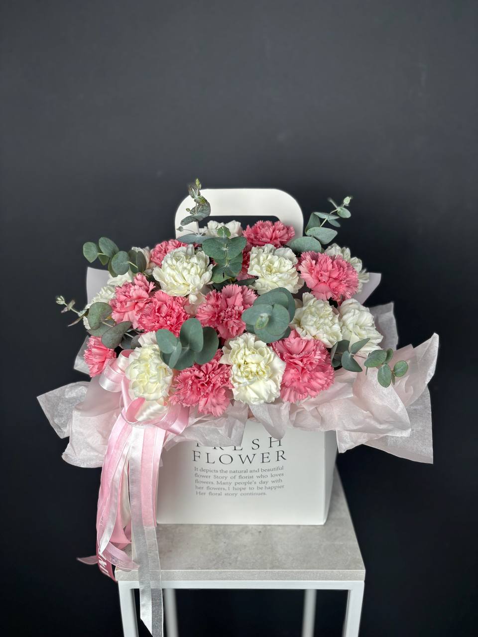 Композиция в сумочке из диантусов и эвкалипта 